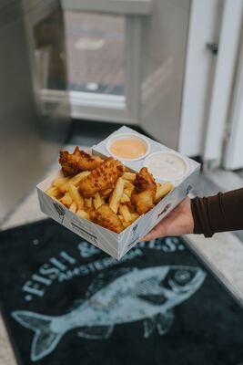 Fish & Fries doos boven de deurmat met logo bij de ingang