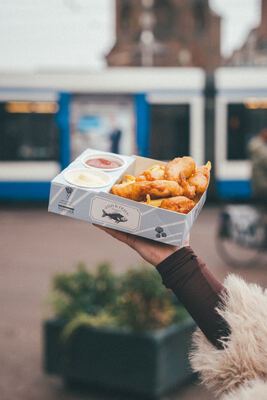 Fish & Fries met een Amsterdamse tram en de Munttoren op de achtergrond