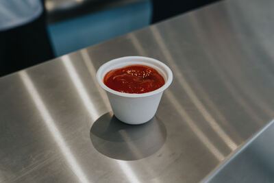 Bakje ketchup op het roestvrijstalen werkblad